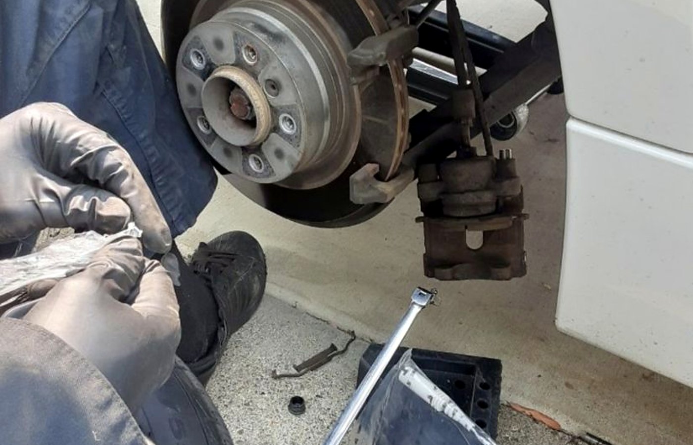 mechanic diagnosing car engine in Anaheim apartment parking lot afternoon